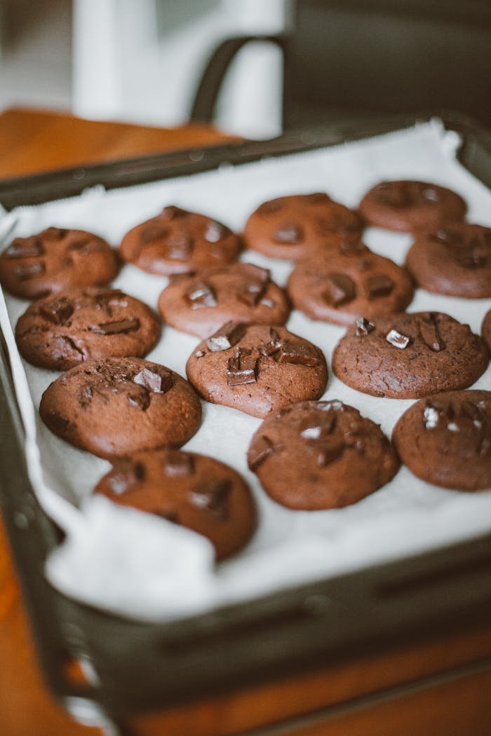 Close-up of homemade chocolate cookies on a baking sheet, perfect for dessert lovers.