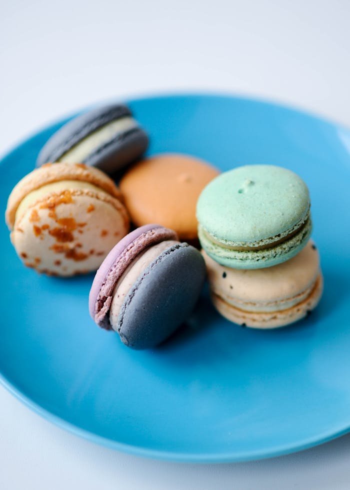 A vibrant selection of macarons displayed on a blue plate, perfect for desserts.